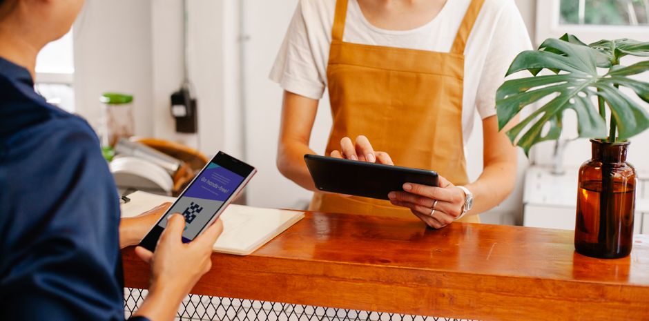 Empleado utilizando smartphone para fichar en punto de venta.